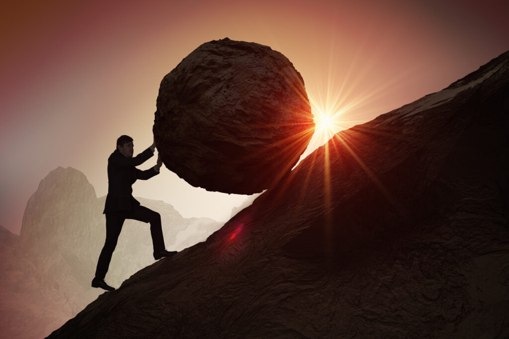 Sisyphus metaphore. Silhouette of businessman pushing heavy stone boulder up on hill. Geldwäscheprävention Geldwäschebeauftragte